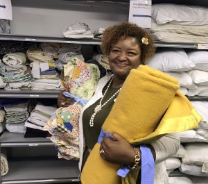 Sandy gathering fabrics at the furniture bank at caritas